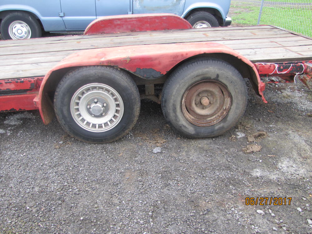 Tires on a red flat bed trailer.