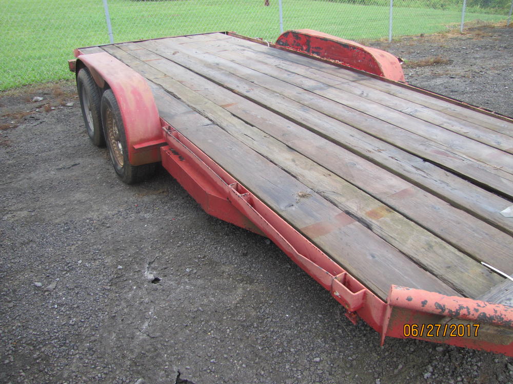 Front view of a red flat bed trailer.