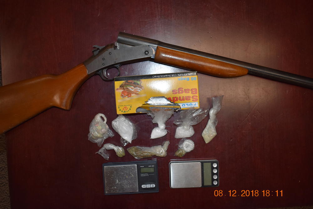 Photo of scales, drugs, and a gun.